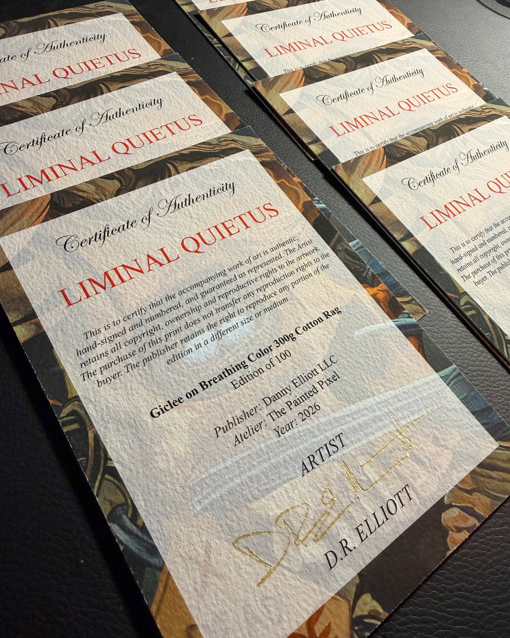 A close-up of several copies of a 'Certificate of Authenticity' for the fine art print 'Liminal Quietus' by D.R. Elliott (Danny Elliott Ink)
